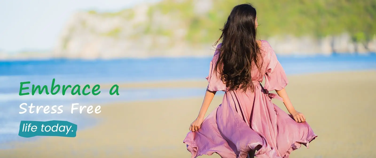 Woman in a pink dress walking freely on the beach, representing a calm and stress-free life